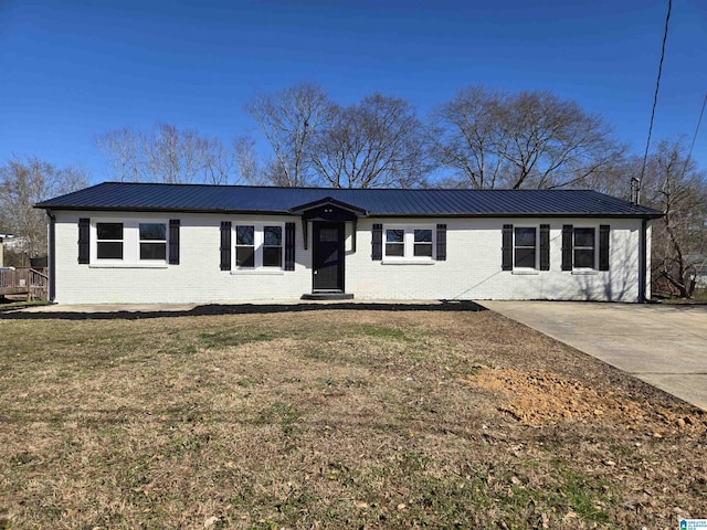 ranch-style house with brick siding, metal roof, and a front lawn