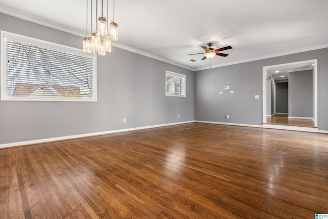 unfurnished room featuring crown molding, baseboards, wood finished floors, and ceiling fan with notable chandelier