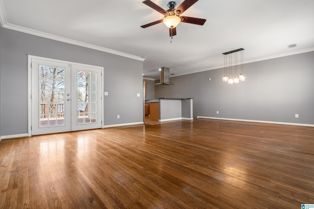 unfurnished living room with ceiling fan with notable chandelier, visible vents, wood finished floors, and french doors