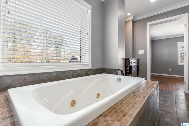 bathroom with plenty of natural light, baseboards, crown molding, and a whirlpool tub