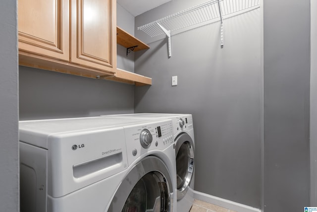 clothes washing area with separate washer and dryer, cabinet space, and baseboards