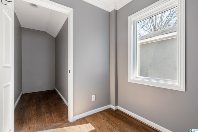 empty room with lofted ceiling, wood finished floors, and baseboards