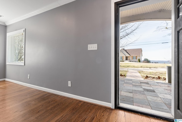 interior space with ornamental molding, visible vents, baseboards, and wood finished floors