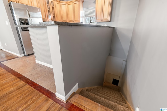 staircase featuring baseboards and wood finished floors