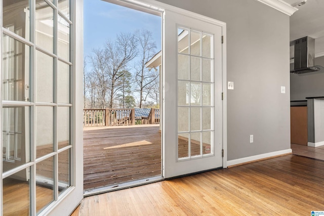 doorway to outside featuring baseboards and wood finished floors