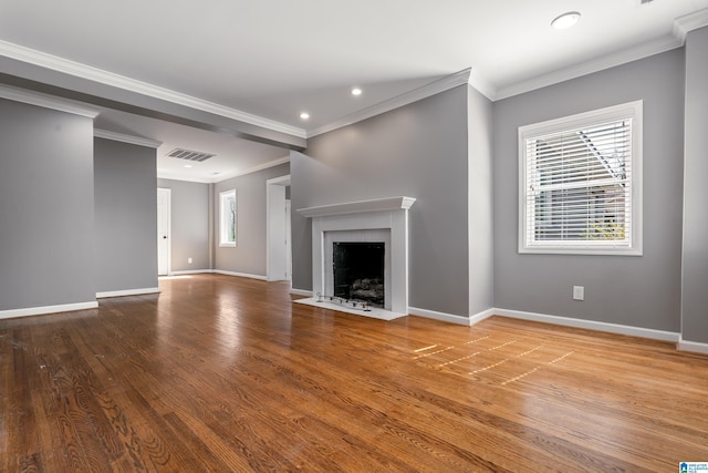 unfurnished living room with a fireplace with flush hearth, visible vents, baseboards, and wood finished floors