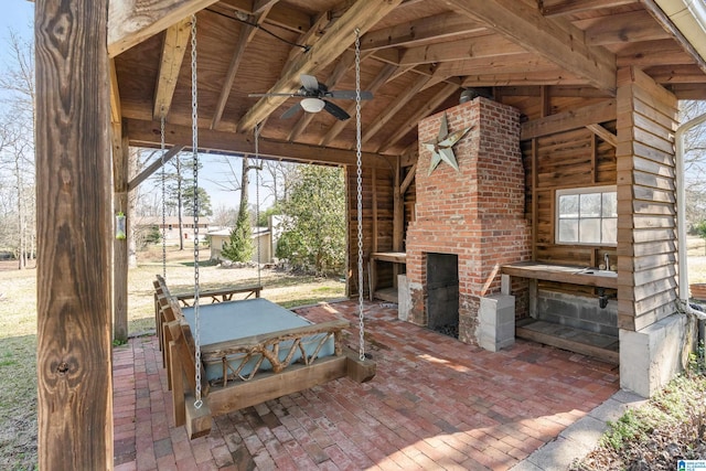 view of patio / terrace featuring a gazebo, a brick fireplace, and a ceiling fan