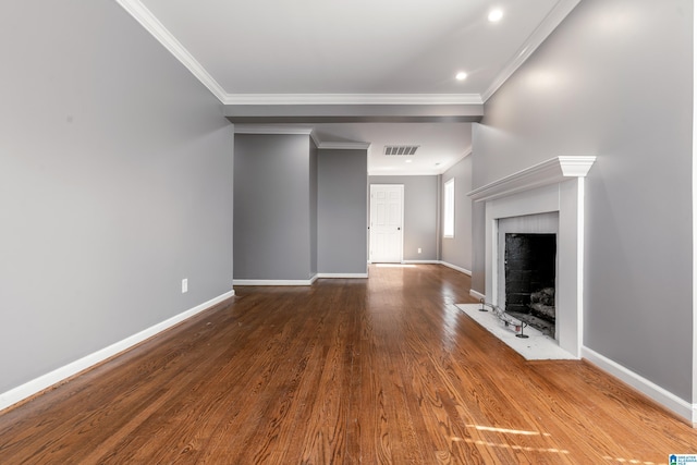 unfurnished living room with wood finished floors, a fireplace with flush hearth, visible vents, and crown molding