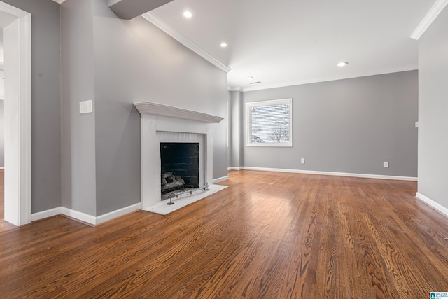 unfurnished living room featuring baseboards, ornamental molding, wood finished floors, and a fireplace with flush hearth