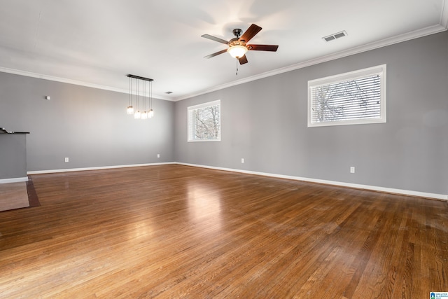 empty room featuring crown molding, visible vents, hardwood / wood-style floors, ceiling fan, and baseboards