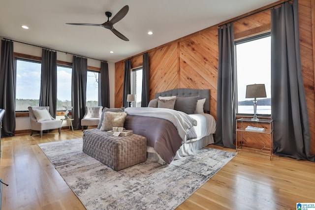 bedroom featuring light wood-style flooring, wooden walls, a ceiling fan, and recessed lighting