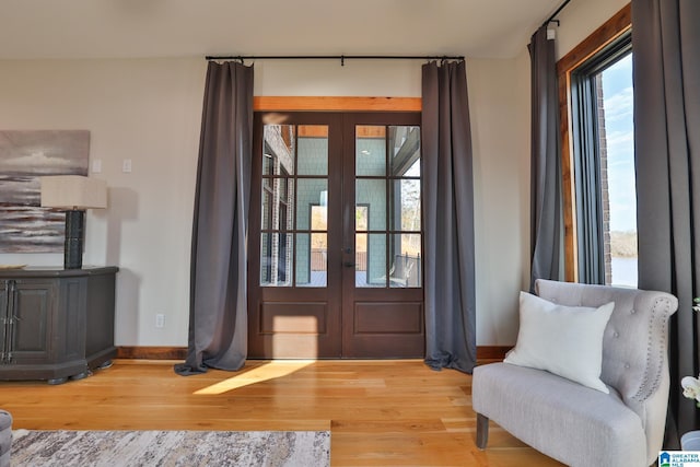 doorway with baseboards, wood finished floors, and french doors