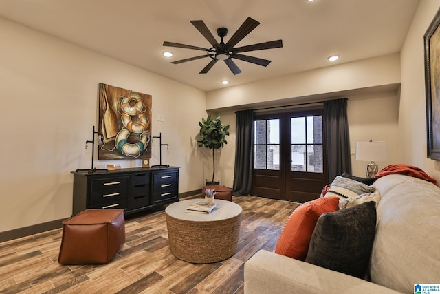 sitting room with baseboards, french doors, wood finished floors, and recessed lighting