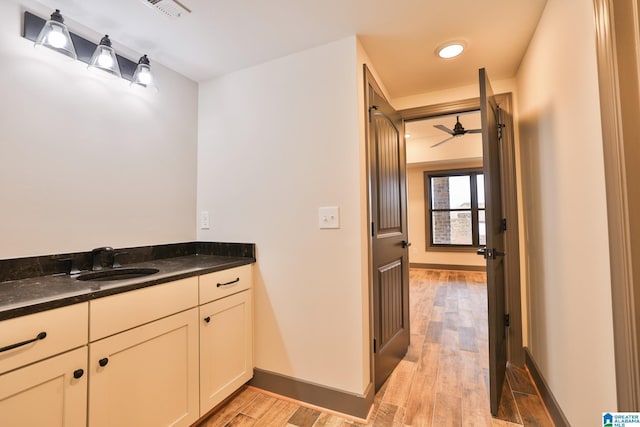 bathroom with baseboards, visible vents, wood finished floors, and vanity