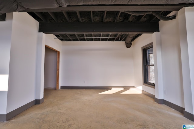 unfurnished room with unfinished concrete flooring and baseboards