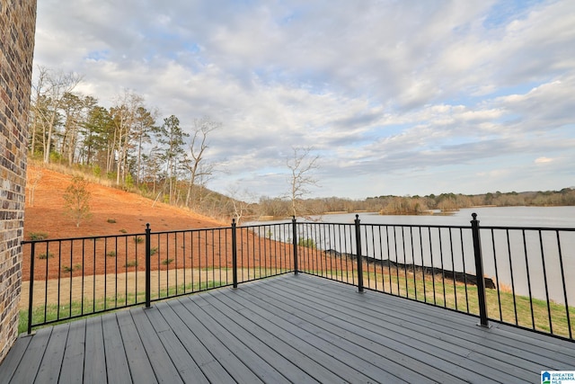 wooden deck featuring a lawn and a water view