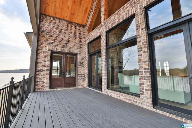 wooden deck featuring french doors and a water view