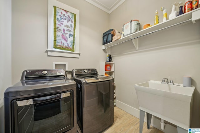 51 Nolen St, Birmingham, AL 35242 - laundry room featuring laundry area, a sink, light wood-style floors, washer and clothes dryer, and crown molding