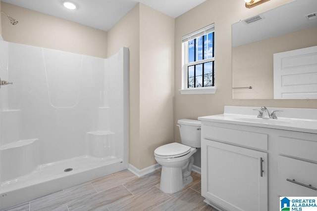 full bath with a stall shower, visible vents, vanity, and toilet