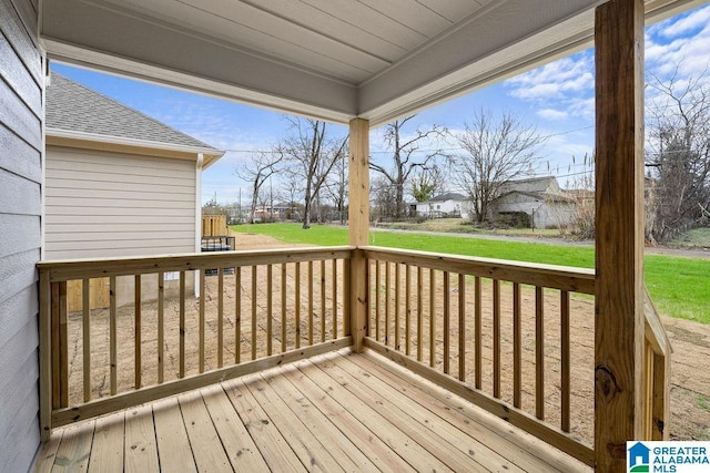 wooden deck featuring a lawn