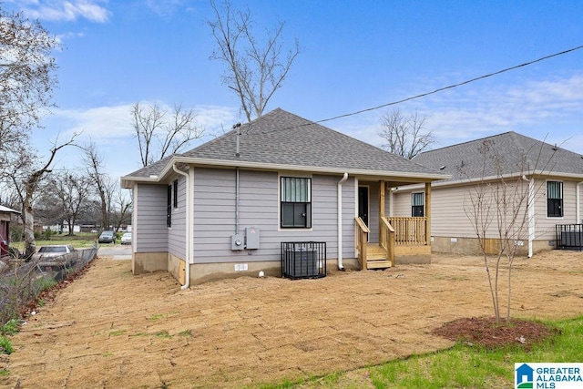 back of property with a shingled roof, crawl space, and covered porch