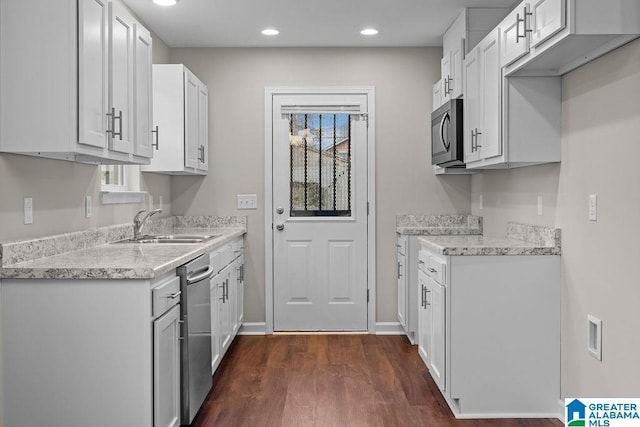 kitchen featuring dark wood-style floors, recessed lighting, appliances with stainless steel finishes, white cabinetry, and a sink