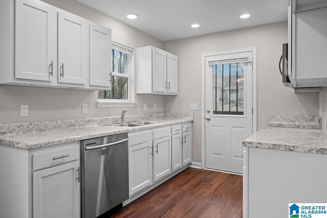 kitchen with dishwasher, light countertops, a sink, and white cabinetry