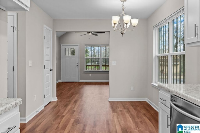 unfurnished dining area featuring baseboards, dark wood-type flooring, and a wealth of natural light