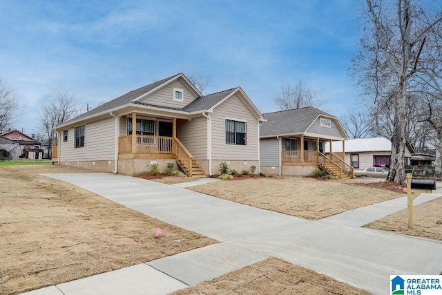 view of front of property featuring roof with shingles, a porch, crawl space, and stairway