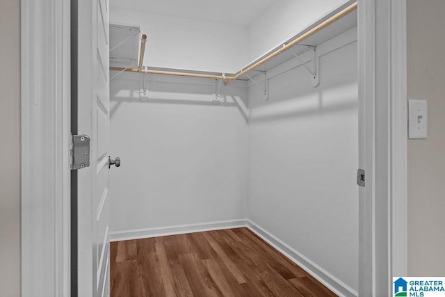 walk in closet with dark wood-style flooring and attic access