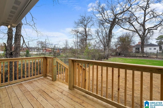 wooden deck featuring a lawn