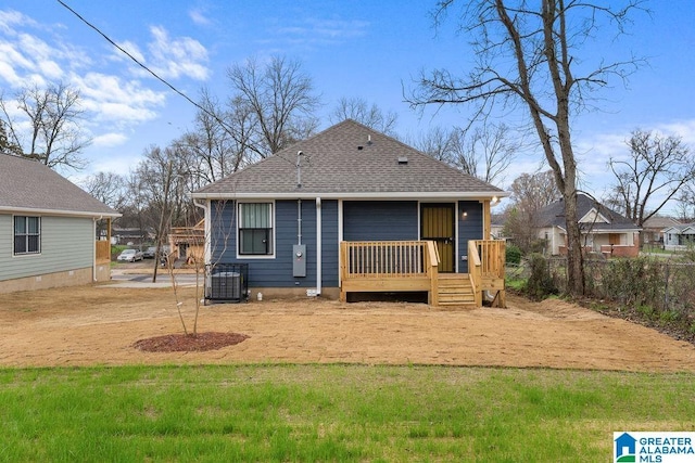 back of house with a shingled roof, cooling unit, and fence