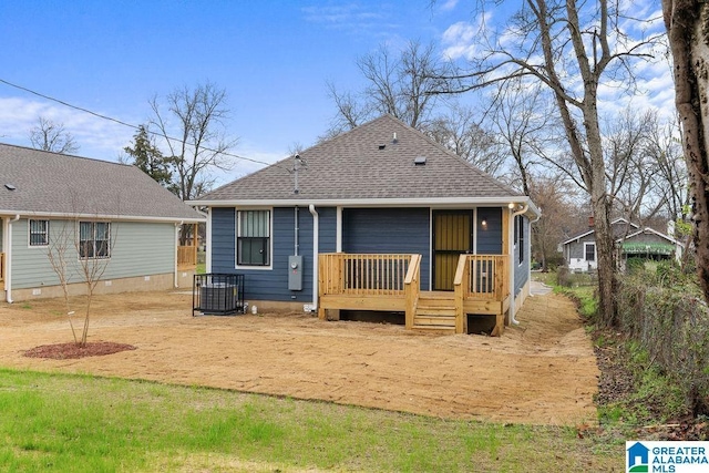 back of house with a shingled roof