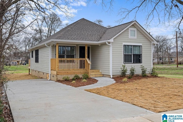 view of front of home with crawl space, a porch, and roof with shingles