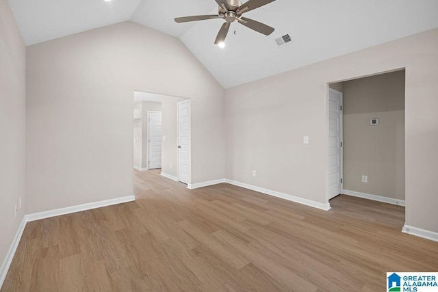 empty room featuring light wood finished floors, visible vents, vaulted ceiling, ceiling fan, and baseboards