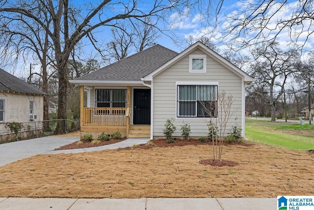 bungalow with a porch and roof with shingles