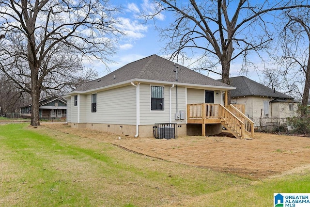 back of property with roof with shingles, a yard, and crawl space