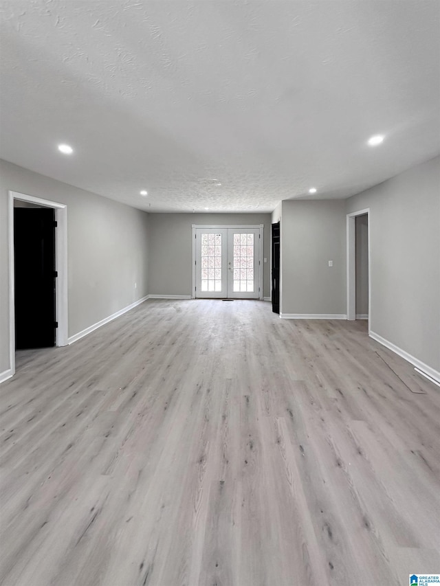 unfurnished room with light wood-style floors, recessed lighting, french doors, and baseboards