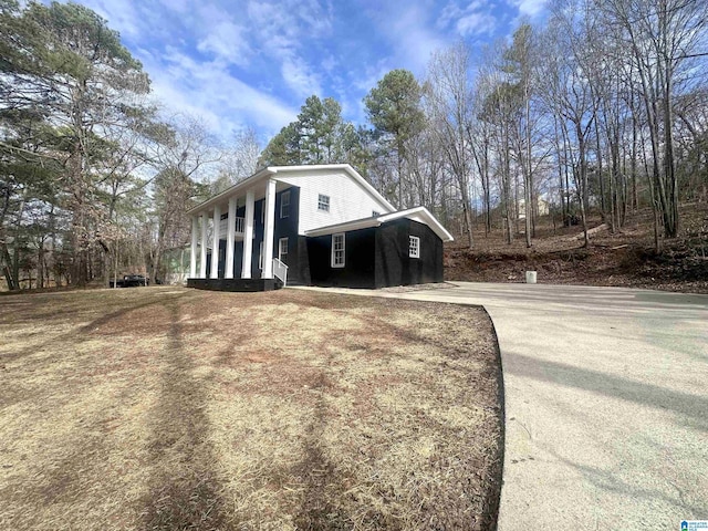 view of side of property with covered porch and driveway