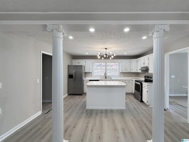 kitchen with decorative columns, appliances with stainless steel finishes, a sink, and a center island