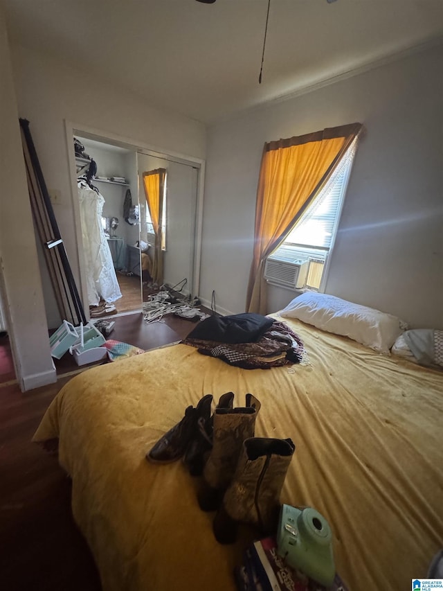 bedroom featuring a closet, cooling unit, and wood finished floors