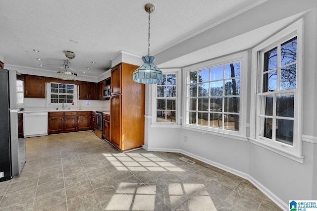 kitchen with stainless steel appliances, visible vents, baseboards, light countertops, and hanging light fixtures