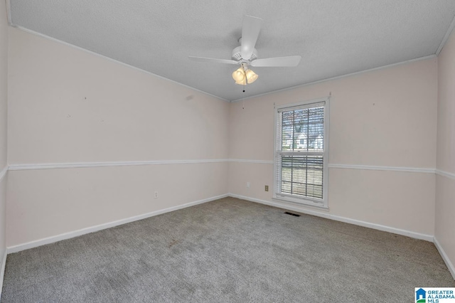 empty room featuring carpet, visible vents, ceiling fan, and a textured ceiling