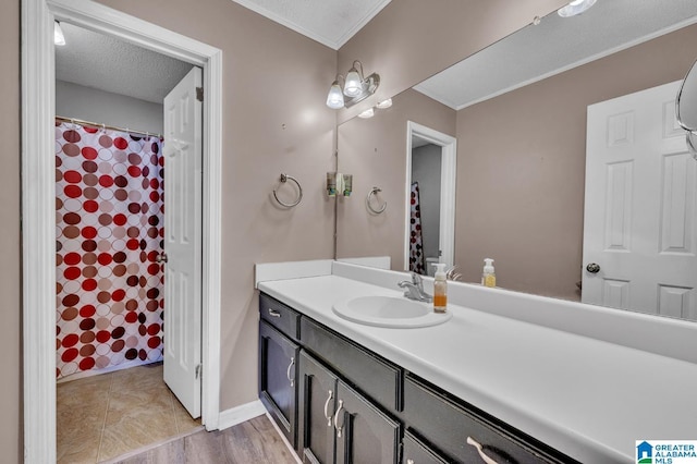 bathroom with baseboards, ornamental molding, a textured ceiling, and vanity