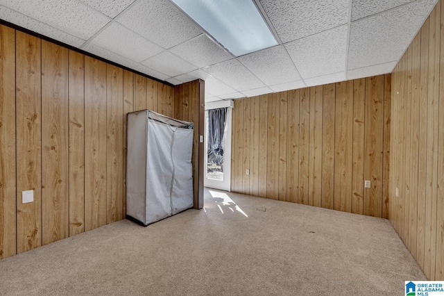 empty room with carpet floors and wood walls