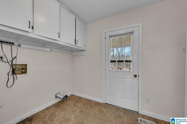 laundry room with cabinet space, visible vents, baseboards, hookup for a washing machine, and a textured ceiling