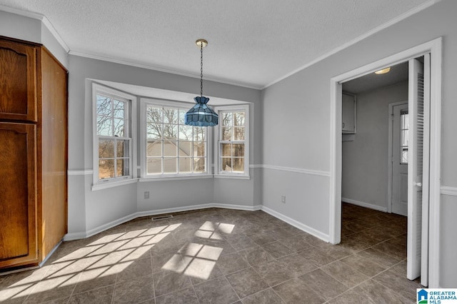 unfurnished dining area featuring crown molding, a textured ceiling, and baseboards