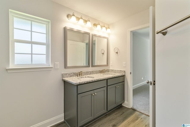 bathroom with a sink, baseboards, and double vanity