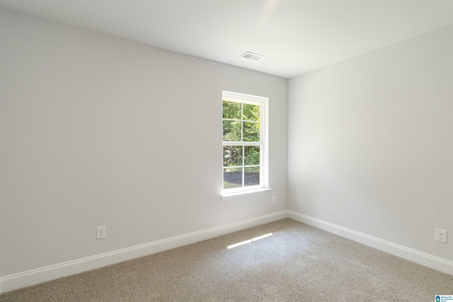 spare room featuring baseboards, visible vents, and carpet flooring