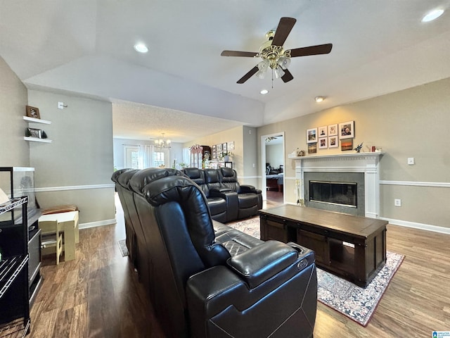 living area featuring a glass covered fireplace, recessed lighting, baseboards, and wood finished floors